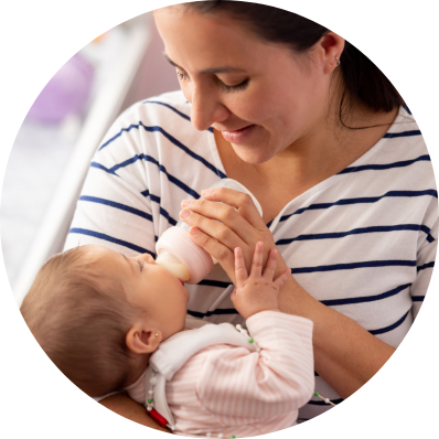 happy mom feeding her baby with infant formula milk using a bottle feeder. 