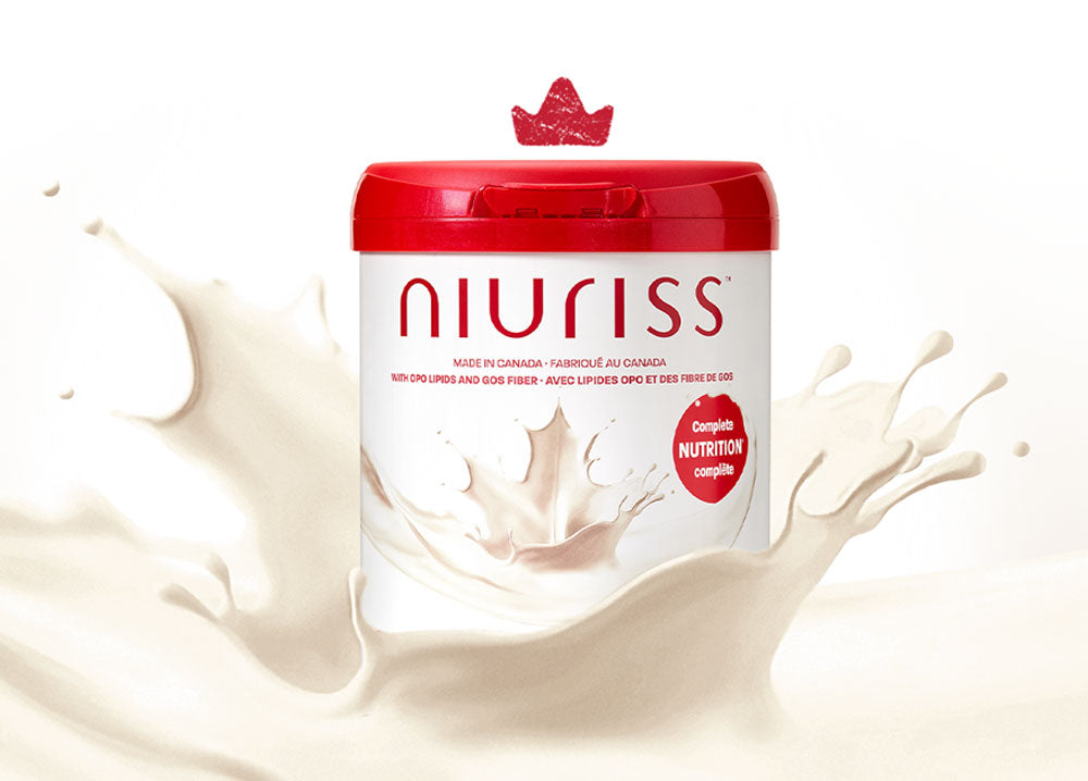 A can of Niuriss Infant Formula falls into a splash of milk. A crown hovers above it, representing our quality formulas.