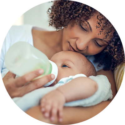 A mother bottle feeds her baby, having opted for combination feeding.