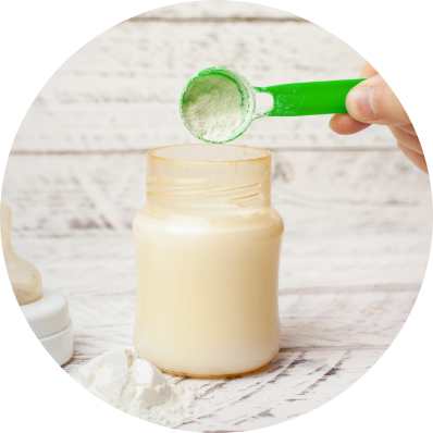 Mom putting a scoop of baby formula powder into the bottle